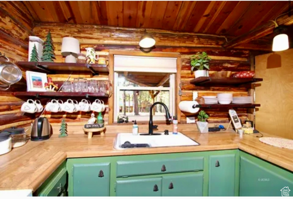 Kitchen with rustic walls, wooden ceiling, open shelves, and light countertops