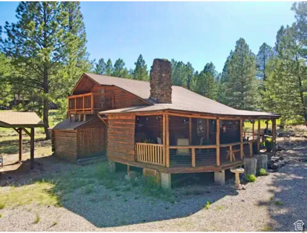 Rear view of house featuring a chimney and a deck