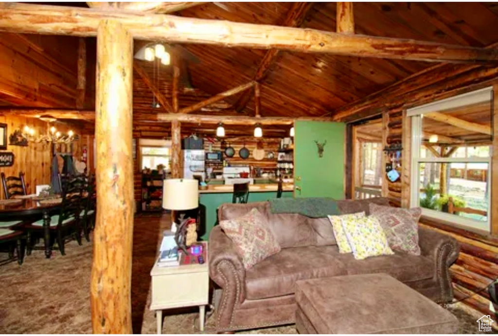 Living room featuring wood ceiling and log walls