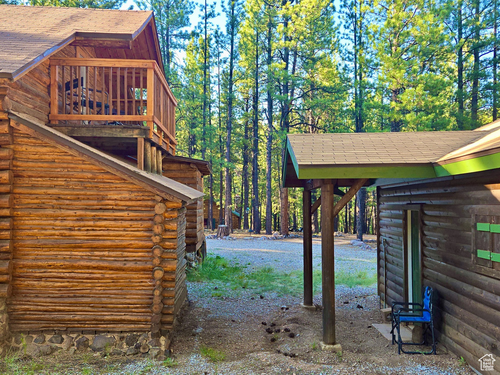 View of side of property with log exterior and roof with shingles