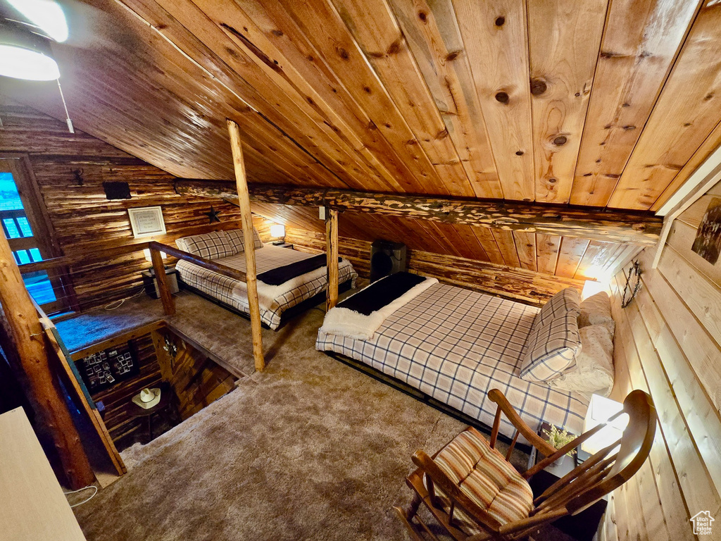 Bedroom featuring wooden ceiling, wood walls, lofted ceiling, and carpet flooring