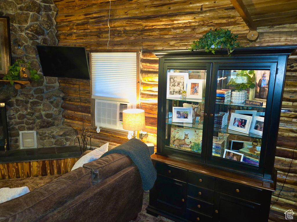 Living area featuring rustic walls, wooden ceiling, and cooling unit