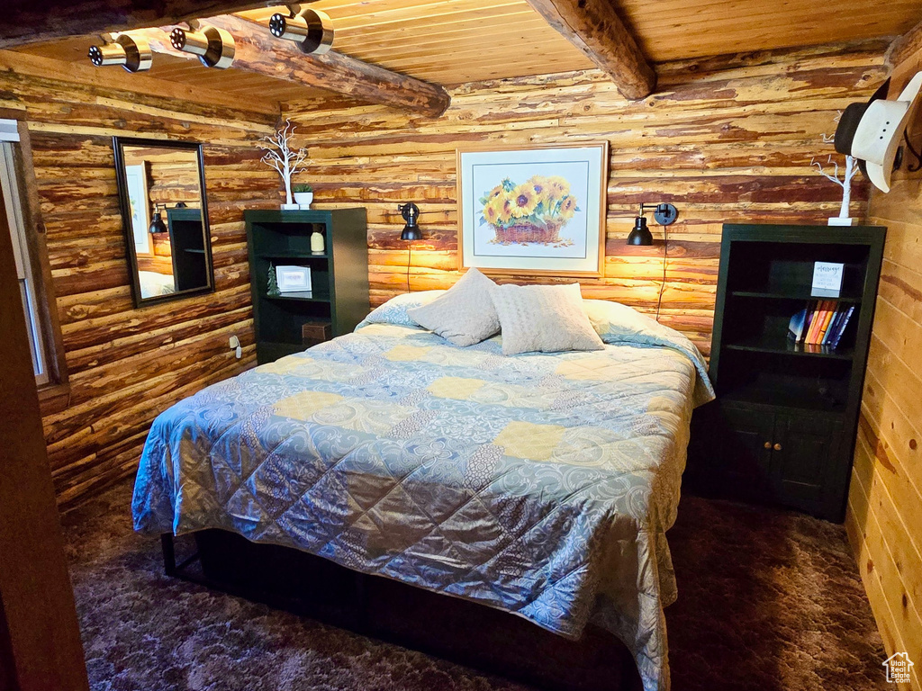 Carpeted bedroom featuring a wooden ceiling with exposed beams and rustic walls