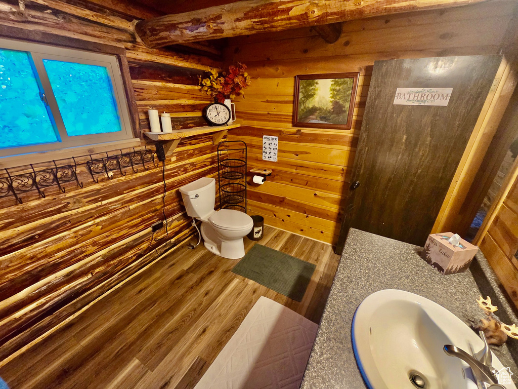 Bathroom with wood finished floors, wooden walls, and vanity