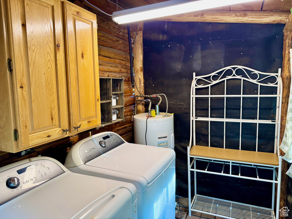 Laundry area with cabinet space, independent washer and dryer, rustic walls, and electric water heater