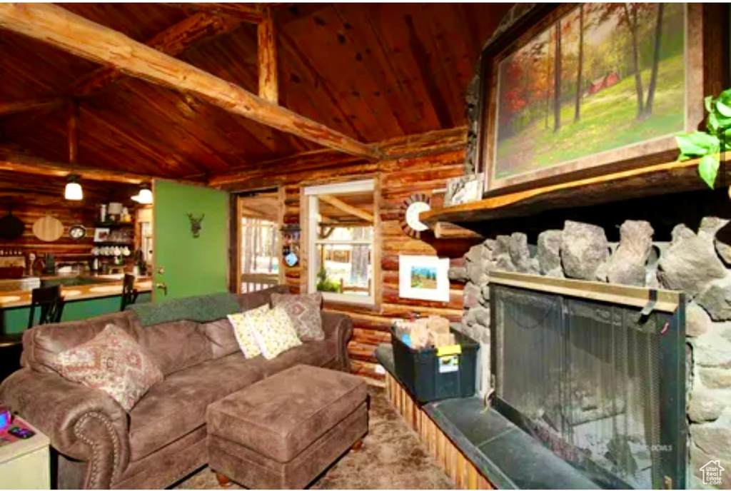 Living area featuring wood ceiling, rustic walls, and a fireplace