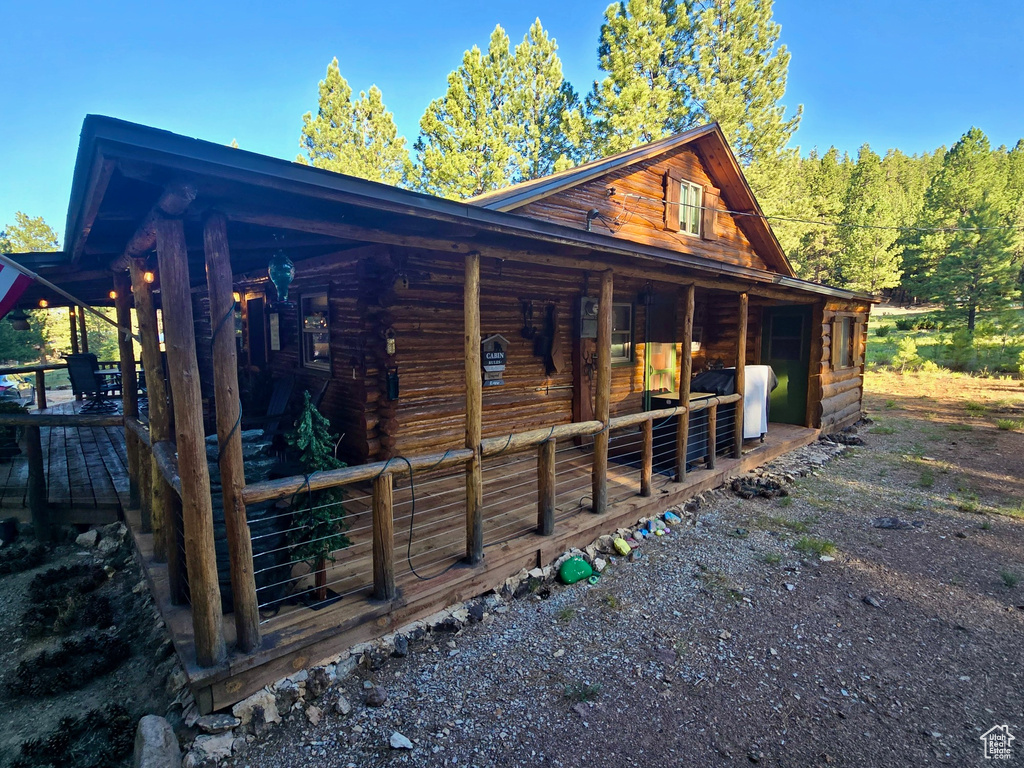 View of side of home with log siding and an exterior structure