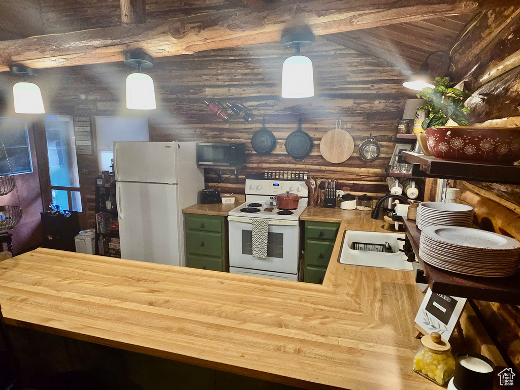Kitchen featuring green cabinetry, butcher block countertops, white appliances, rustic walls, and a wooden ceiling with exposed beams