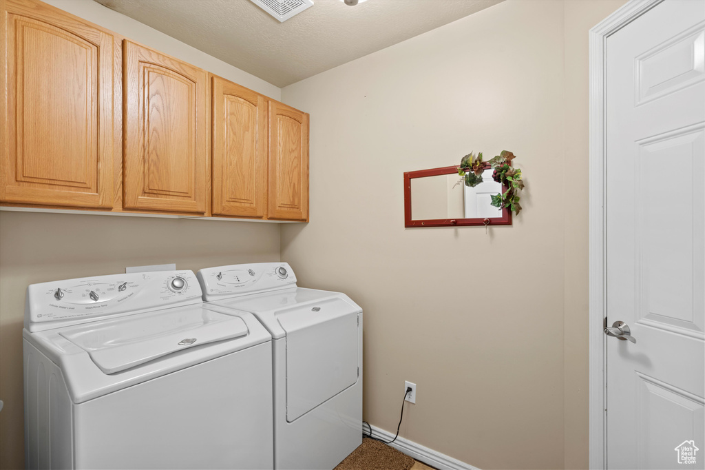 Laundry area with independent washer and dryer and cabinet space