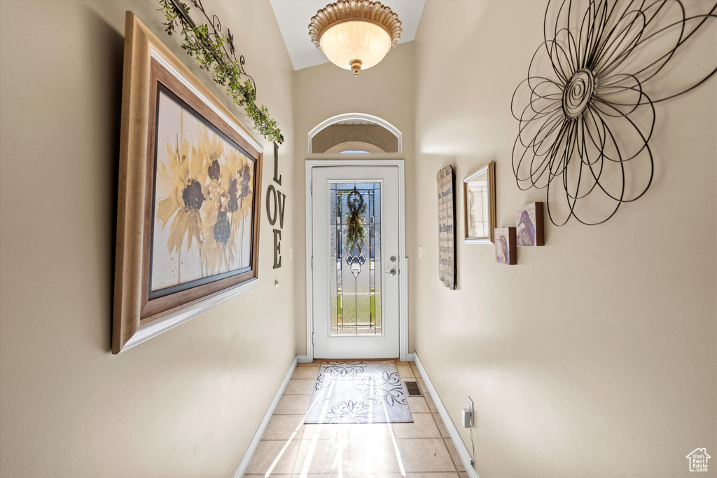 Doorway to outside with baseboards and light tile patterned floors