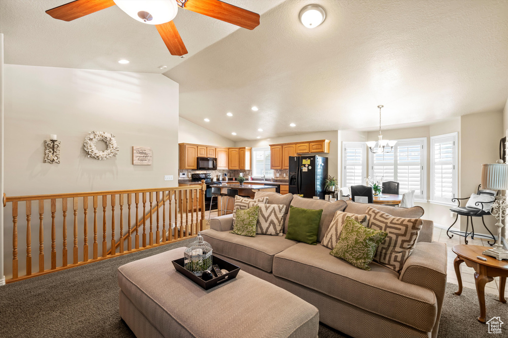 Carpeted living area with a chandelier, a ceiling fan, recessed lighting, and lofted ceiling