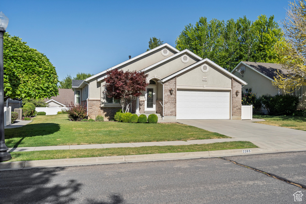 View of front of house featuring brick siding, a garage, and driveway