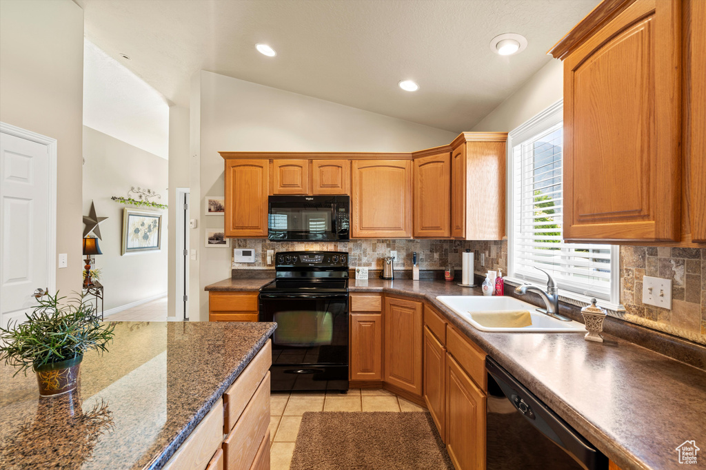 Kitchen featuring black appliances, vaulted ceiling, decorative backsplash, light tile patterned floors, and recessed lighting