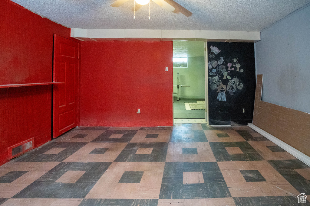 Unfurnished room with a textured ceiling, ceiling fan, and tile patterned floors
