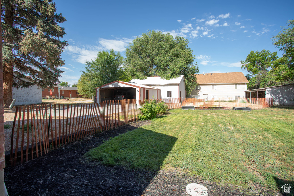 View of yard with an outdoor structure and a detached carport