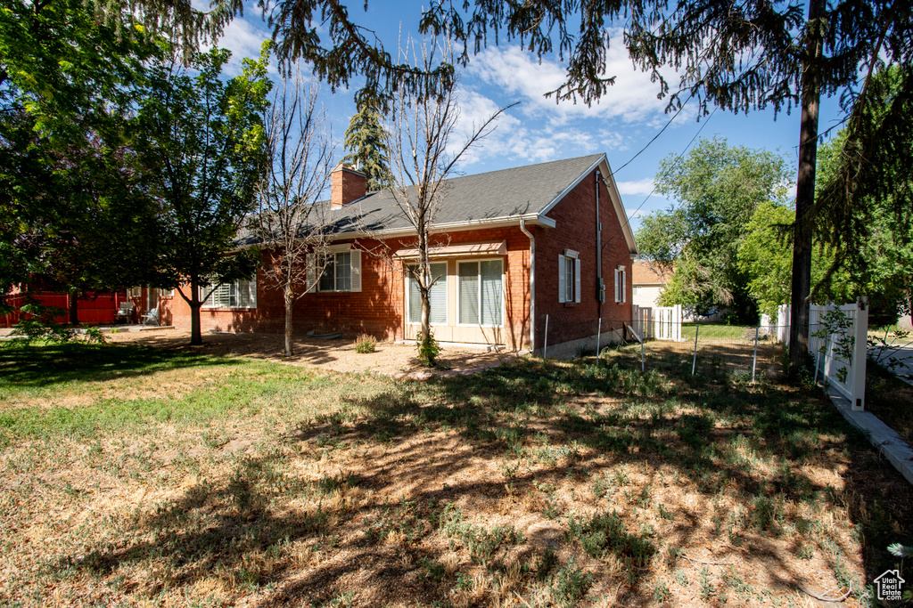 Back of property with brick siding and a chimney