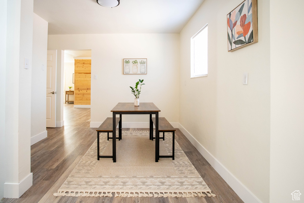 Corridor with dark wood-type flooring and baseboards
