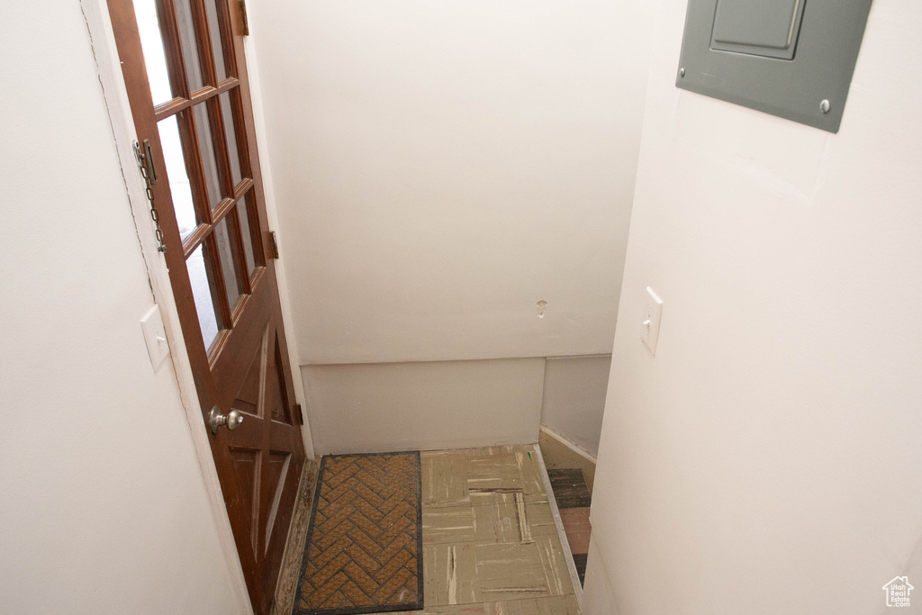 Hall featuring baseboards and electric panel