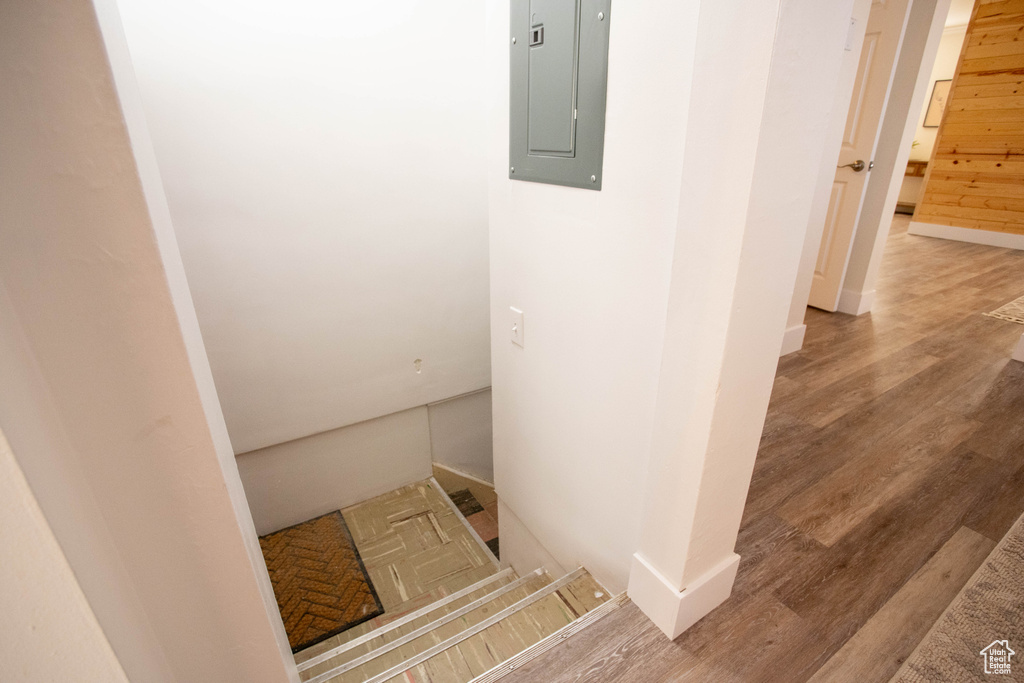 Stairway featuring electric panel and wood finished floors