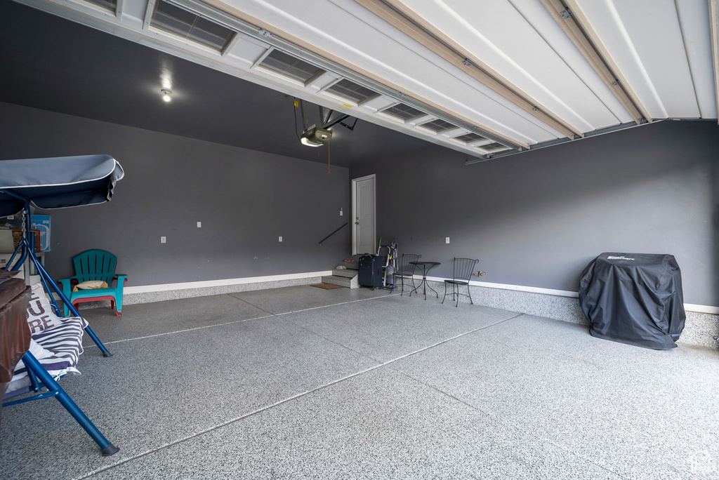 Garage with a garage door opener and baseboards