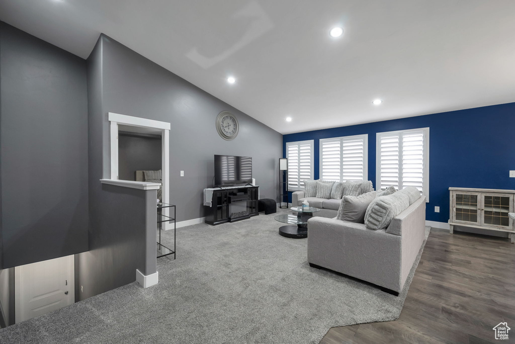Living area with vaulted ceiling, recessed lighting, and wood finished floors