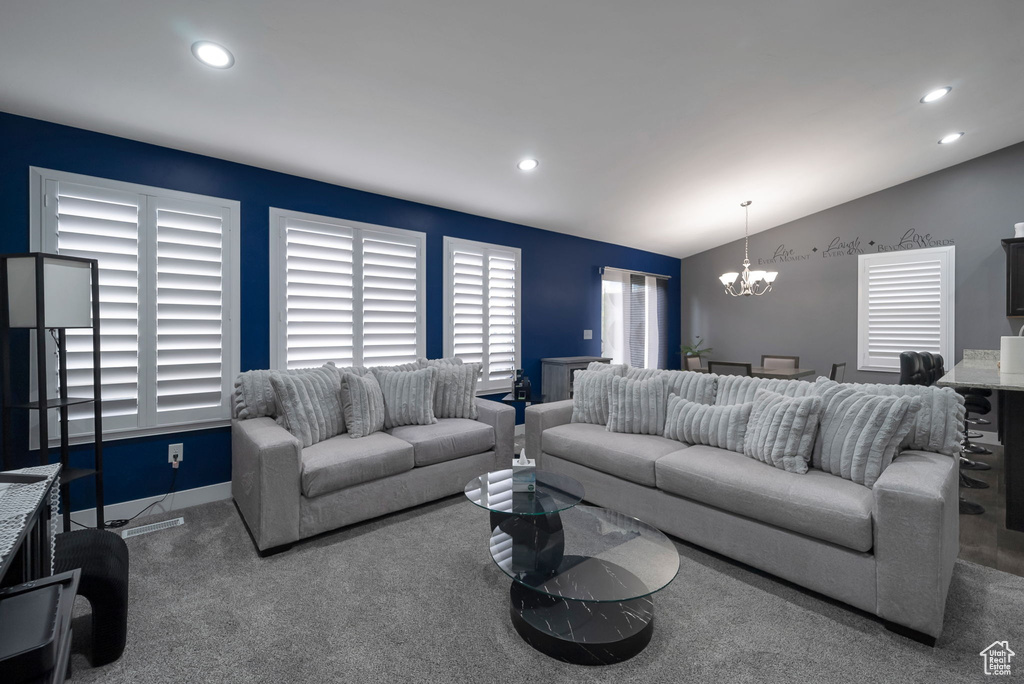 Carpeted living area featuring a chandelier, recessed lighting, and vaulted ceiling