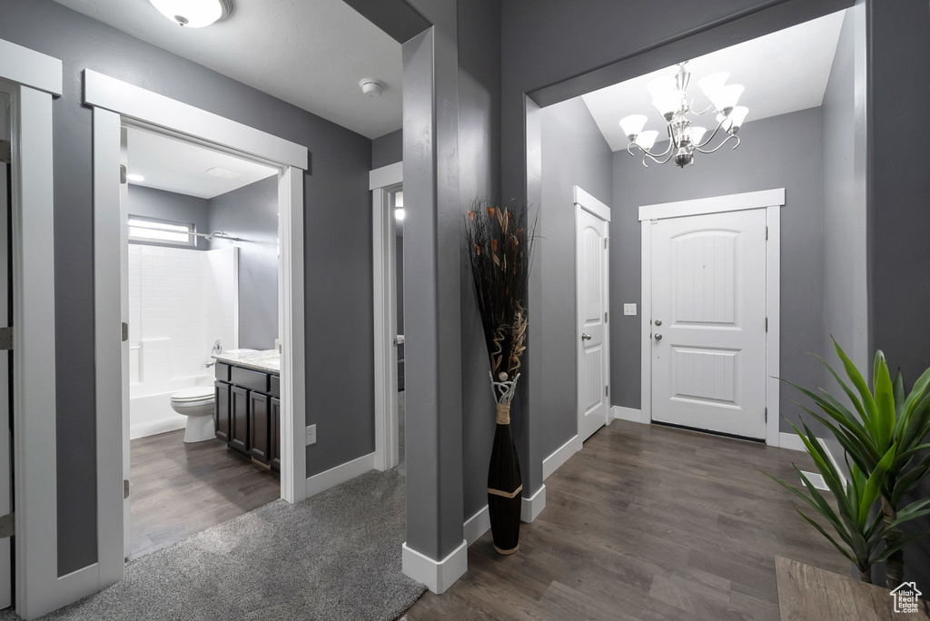 Entrance foyer featuring a chandelier and dark wood-style flooring