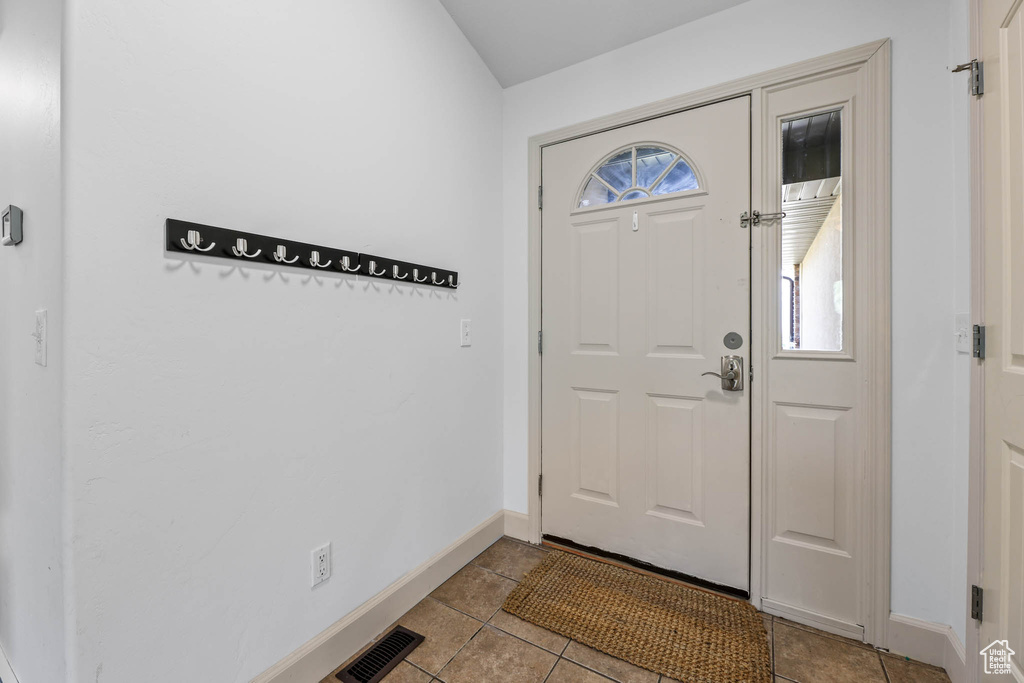 Entrance foyer featuring baseboards and light tile patterned floors