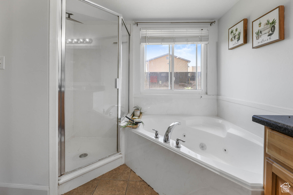 Full bathroom with a stall shower, a tub with jets, and tile patterned flooring