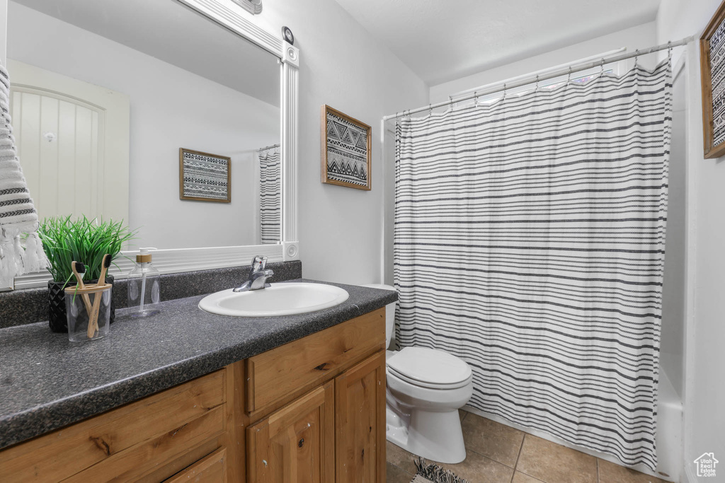 Bathroom with vanity, tile patterned flooring, and shower / bathtub combination with curtain
