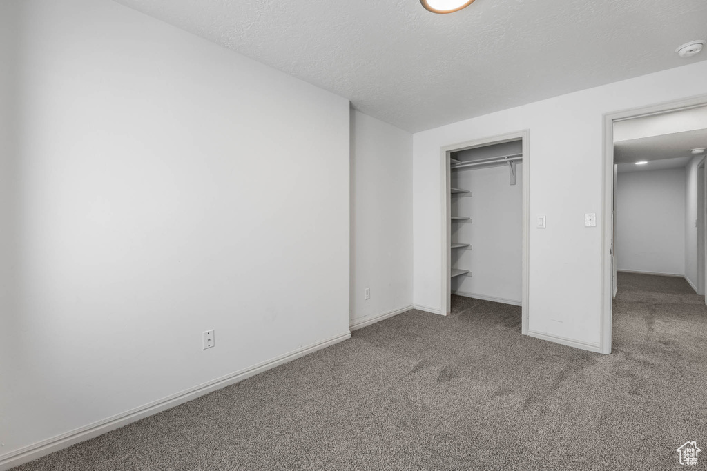 Unfurnished bedroom with carpet and baseboards