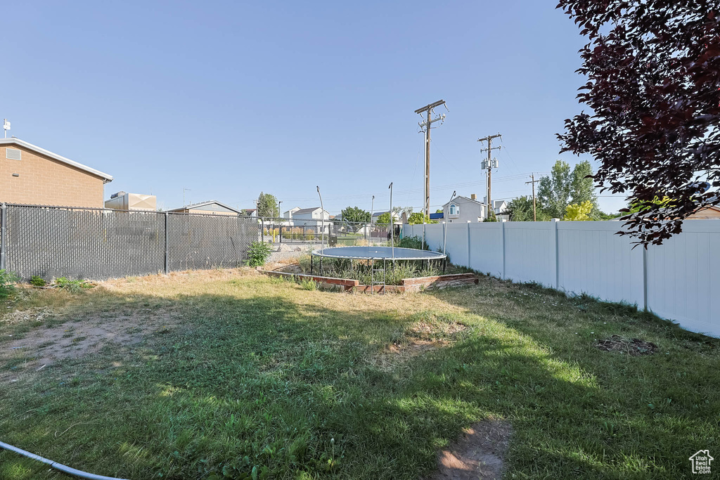 Fenced backyard with a trampoline