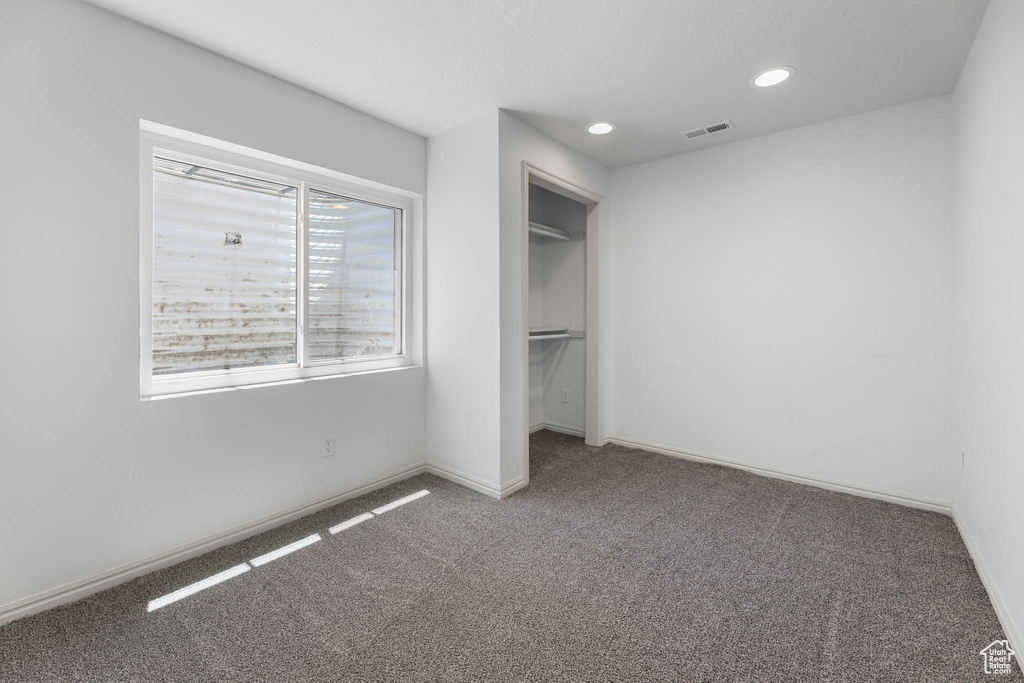 Unfurnished bedroom featuring carpet flooring, recessed lighting, and a closet