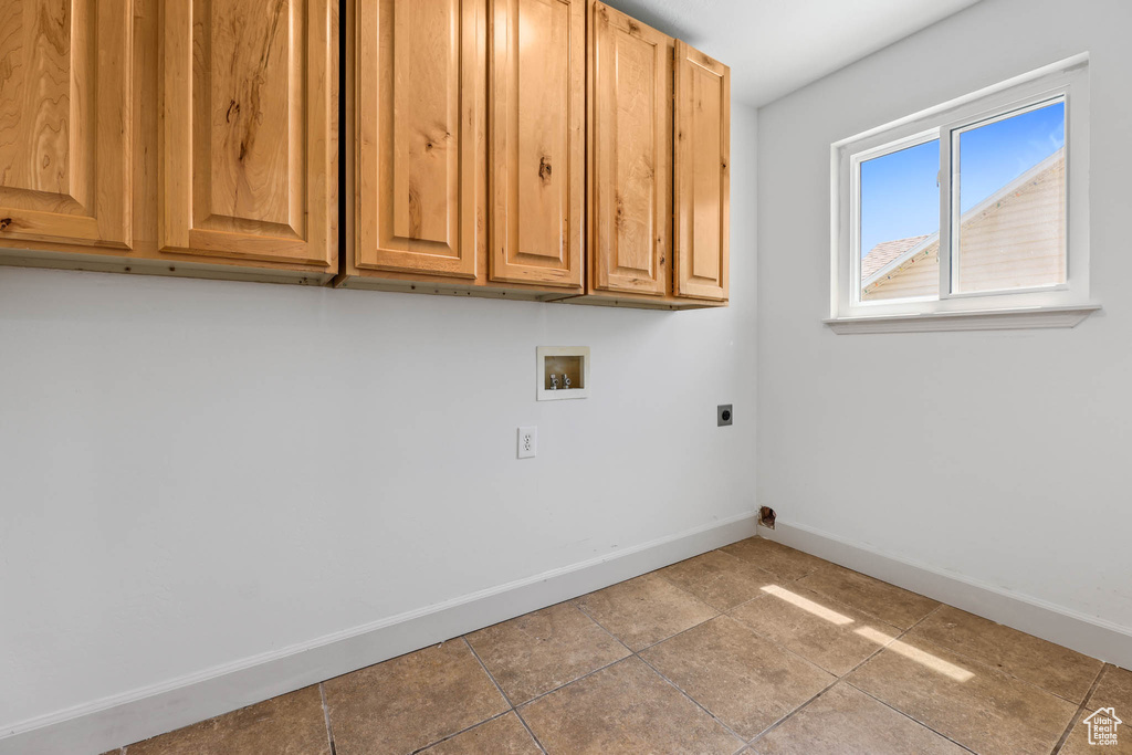 Laundry room with hookup for a washing machine, cabinet space, electric dryer hookup, and tile patterned flooring
