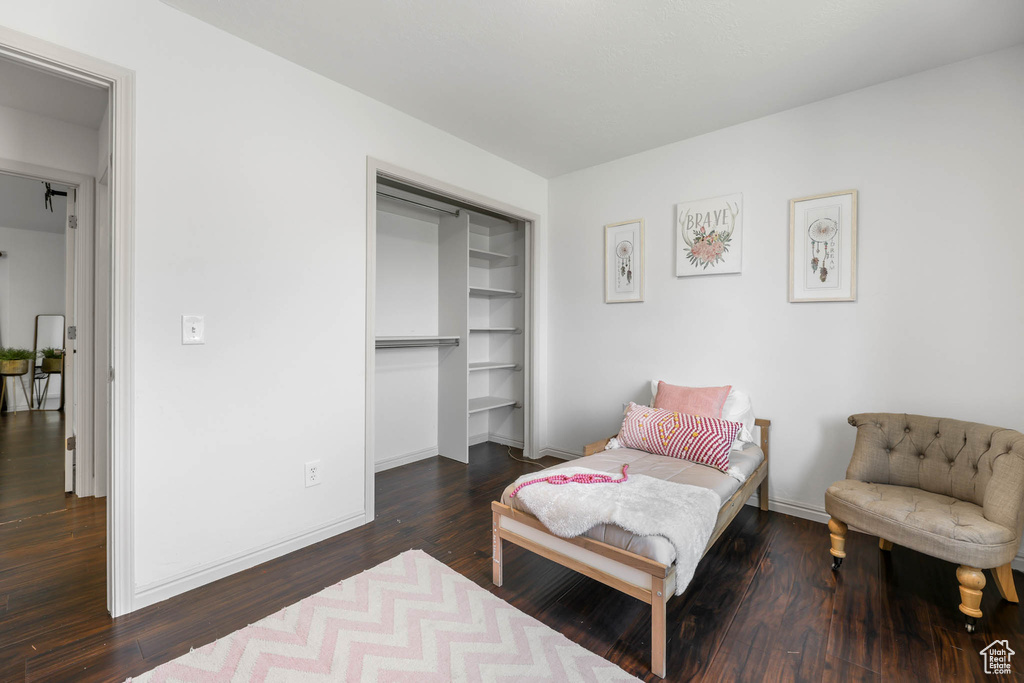 Bedroom with wood finished floors and a closet