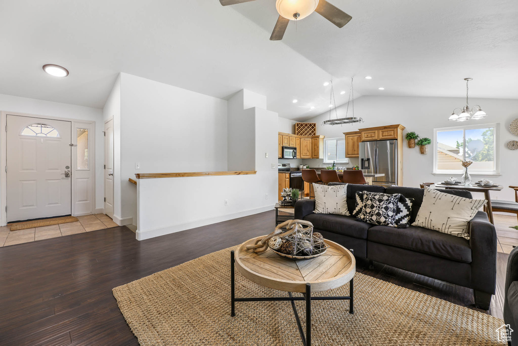Living area with vaulted ceiling, light wood finished floors, plenty of natural light, a ceiling fan, and recessed lighting