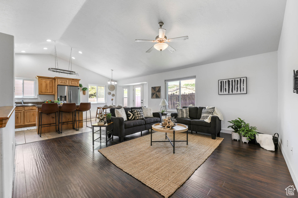 Living area featuring lofted ceiling, a ceiling fan, healthy amount of natural light, wood finished floors, and recessed lighting