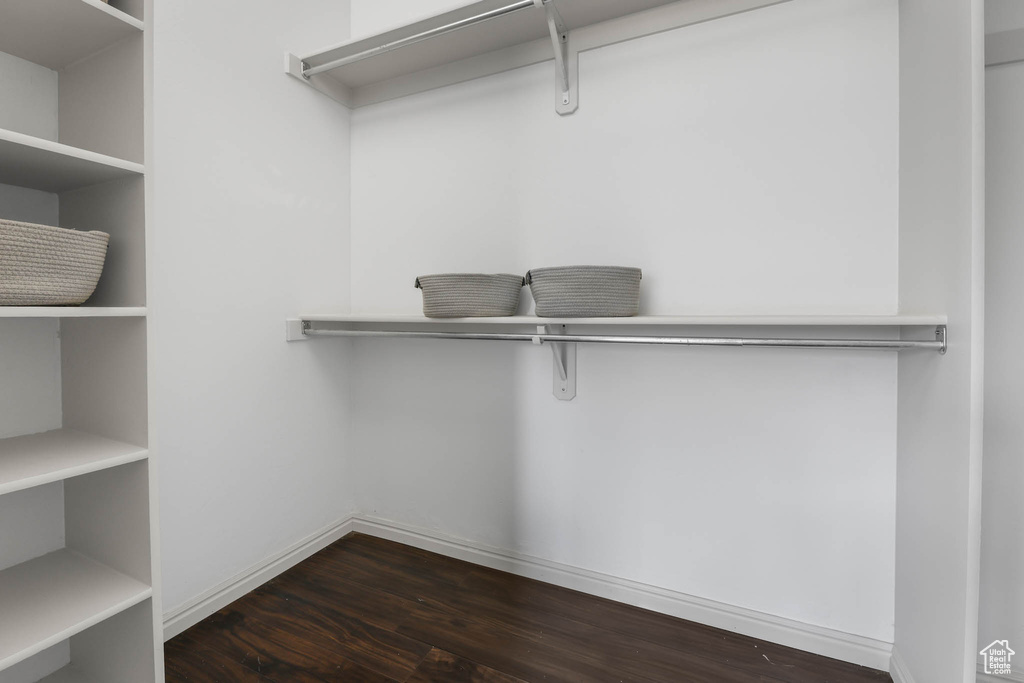 Spacious closet with dark wood-style floors