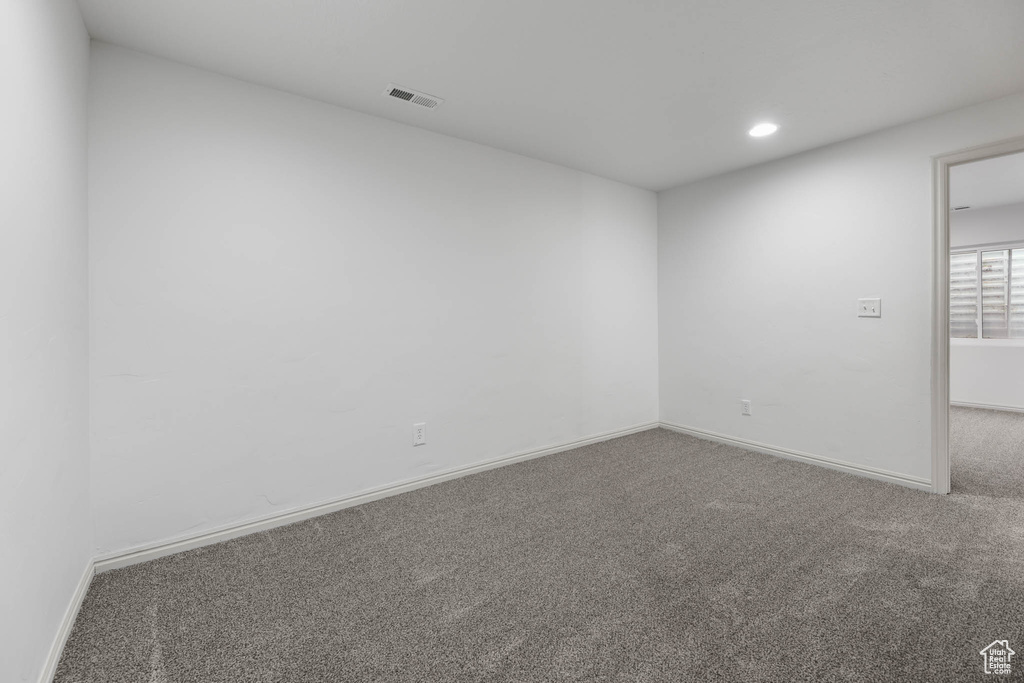 Carpeted empty room with baseboards and recessed lighting