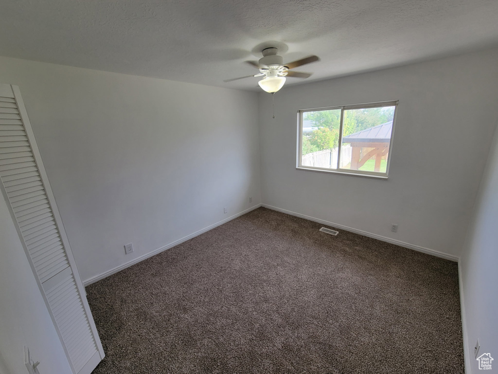 Unfurnished bedroom featuring carpet floors, a ceiling fan, and a closet
