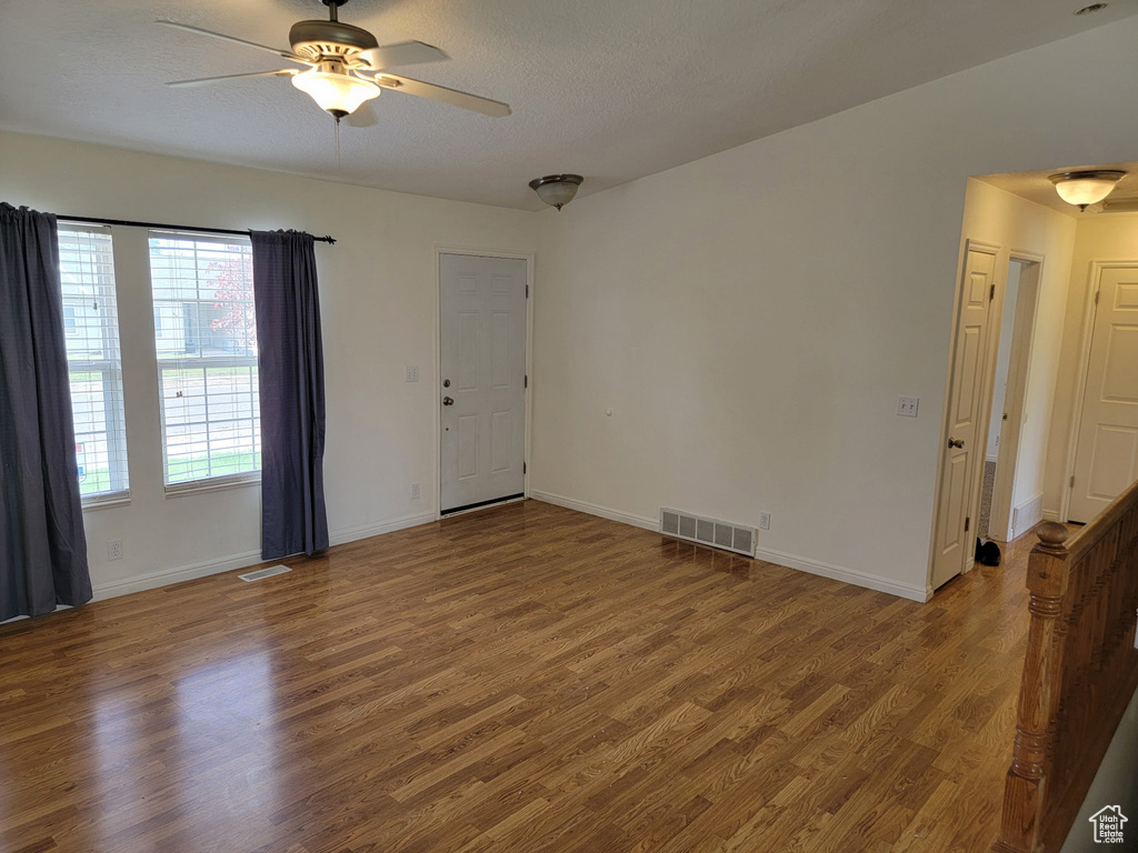 Unfurnished room with wood finished floors and a ceiling fan