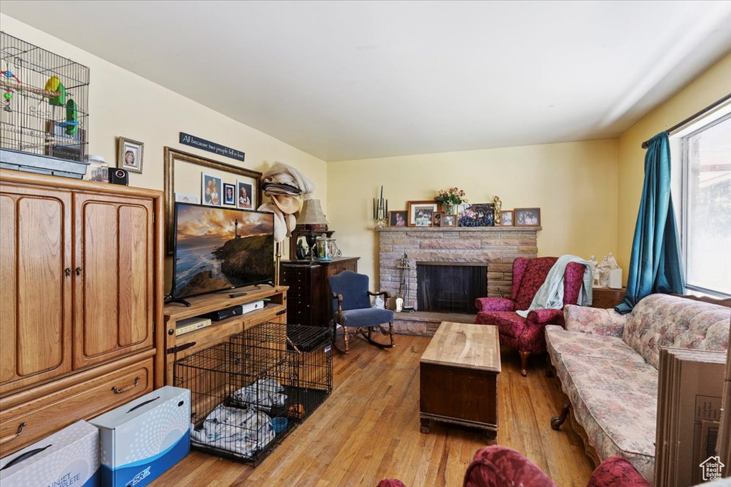 Living room with wood finished floors and a stone fireplace