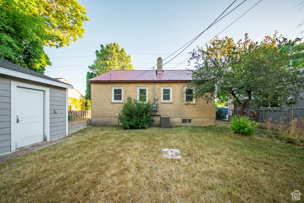 Rear view of house featuring a metal roof and brick siding