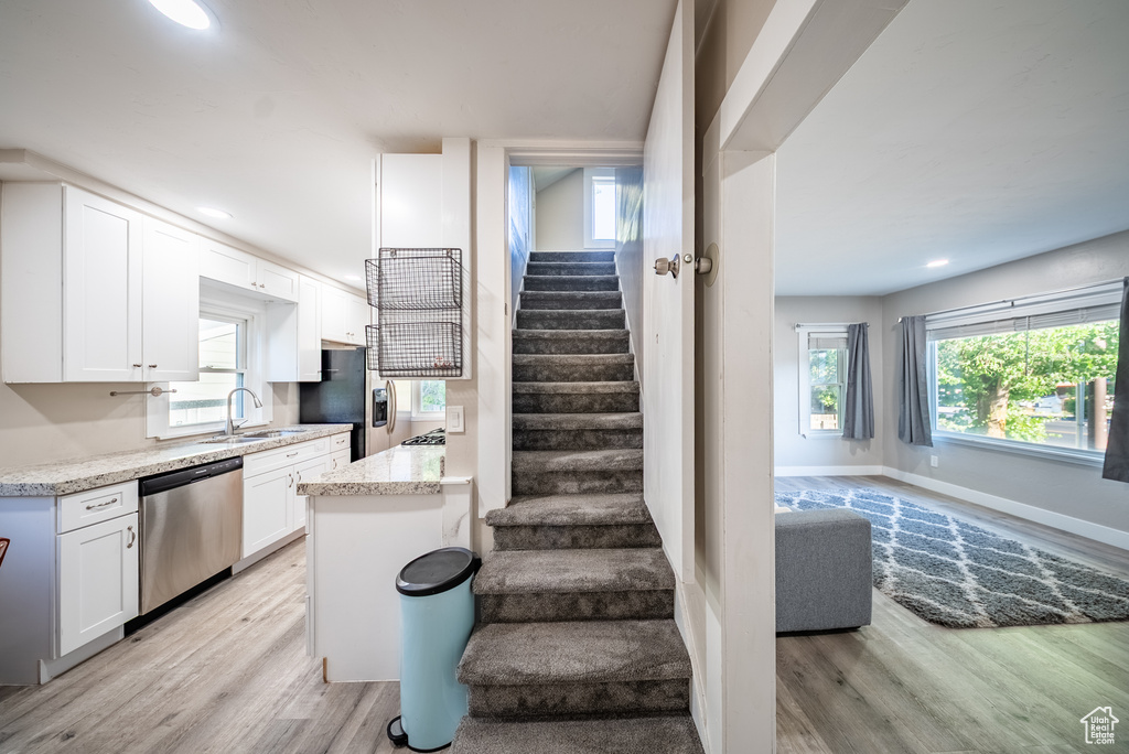 Stairs featuring wood finished floors and recessed lighting