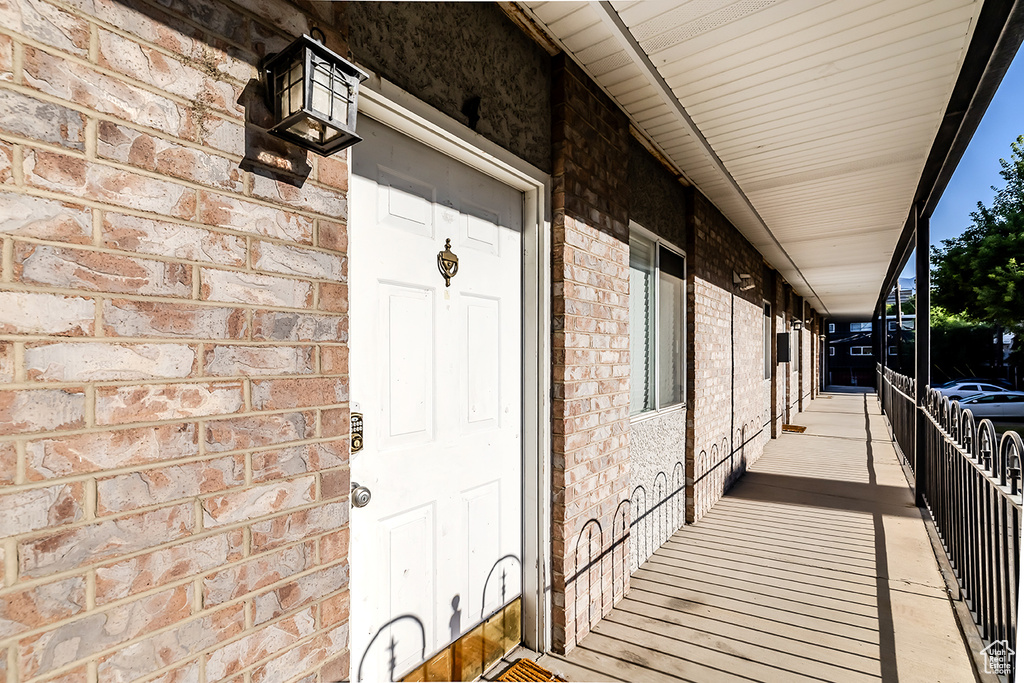 Entrance to property featuring brick siding and a porch