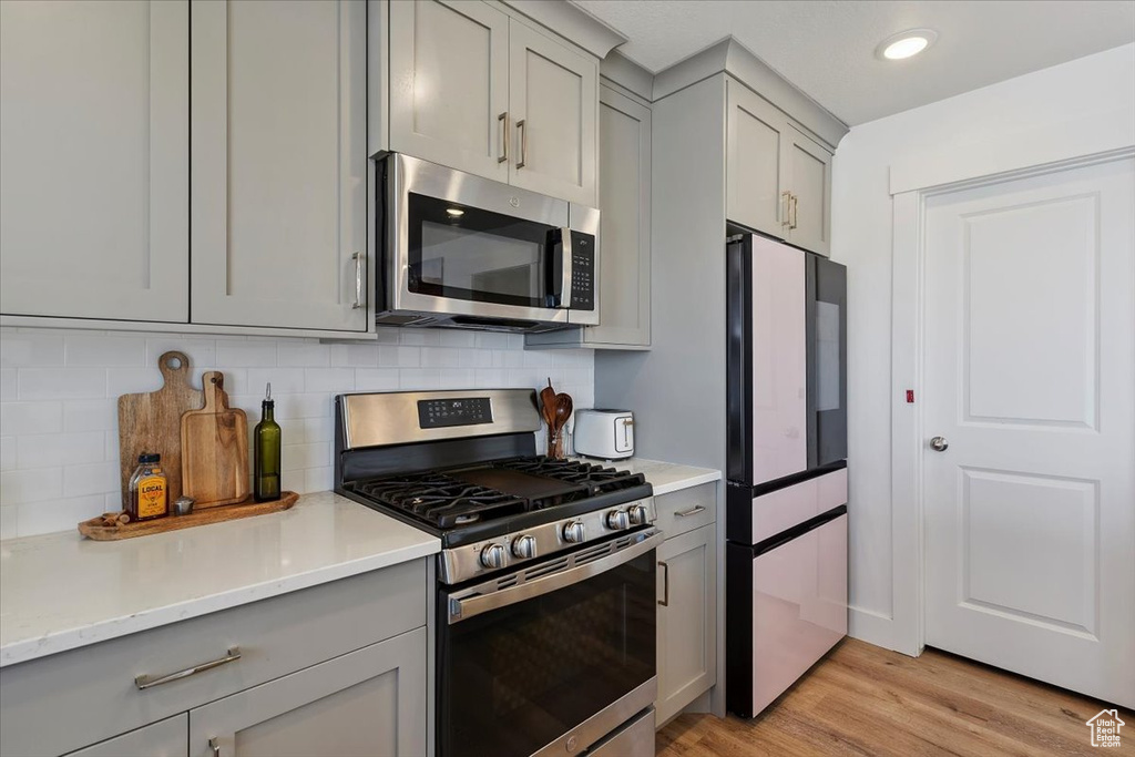 Kitchen with appliances with stainless steel finishes and gray cabinets