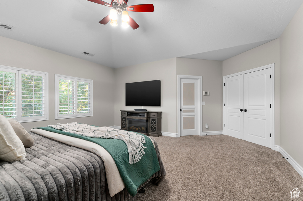 Bedroom with carpet floors, ceiling fan, and a closet