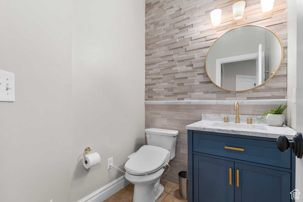 Bathroom with tile patterned flooring, vanity, and tile walls