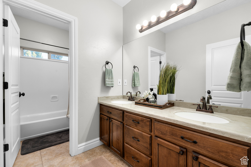 Full bath with double vanity,  shower combination, and tile patterned floors