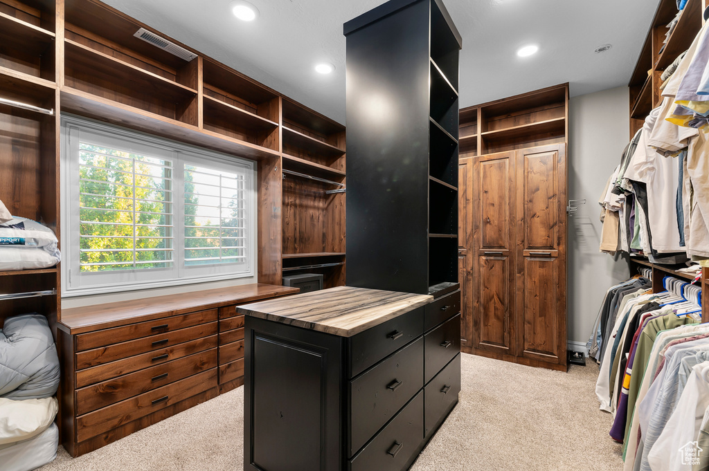 Walk in closet featuring light colored carpet